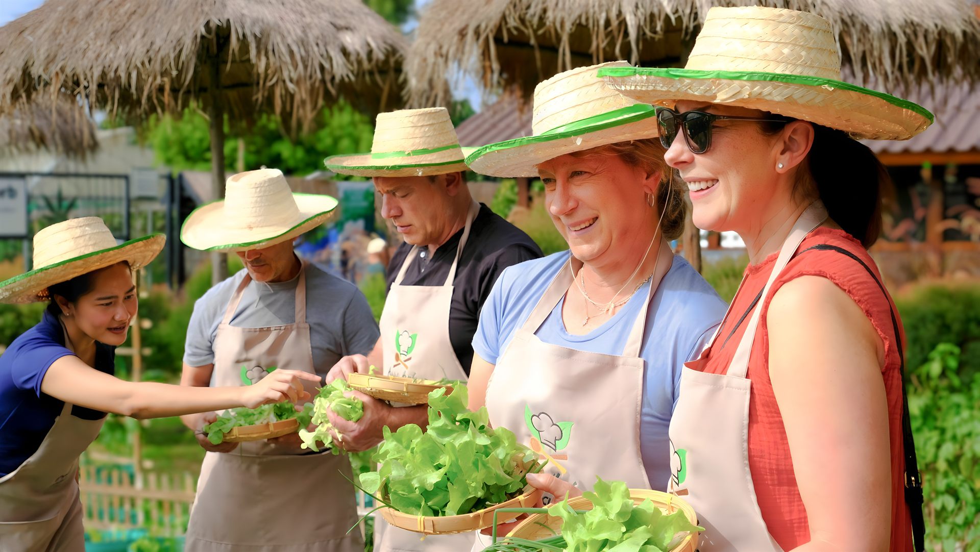Guests harvesting fresh tomatoes from the organic farm at Happy Herb Cooking Class in Chiang Mai